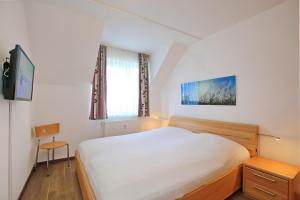 a bedroom with a large white bed and a window at Haffblick Wohnung 11 in Boltenhagen