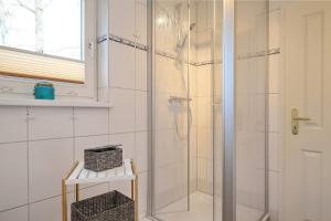 a shower with a glass door in a bathroom at Strandvilla Krabbe Wohnung 03 in Boltenhagen