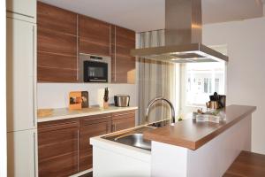 una cocina con armarios de madera y fregadero en Strandappartement in Binz, en Binz