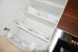 a kitchen cabinet with plates and dishes in it at Strandappartement in Binz in Binz