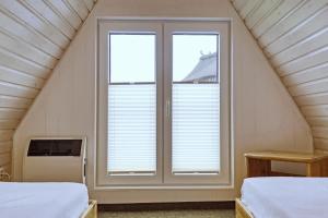 a bedroom with two beds and a window at An der Steilküste Finnhütte 01 in Boltenhagen