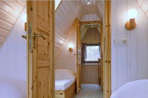 a small attic room with a bed and a door at An der Steilküste Finnhütte 03 in Boltenhagen