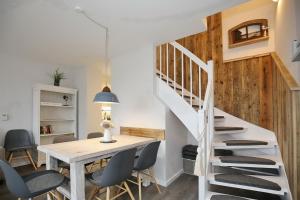 a dining room with a table and chairs and a staircase at Papillon Wohnung 01-7 in Boltenhagen