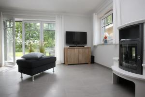 a living room with a television and a chair at Reethaus Am Mariannenweg 11a in Boltenhagen