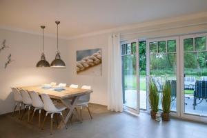 a dining room with a wooden table and chairs at Reethaus Am Mariannenweg 11a in Boltenhagen