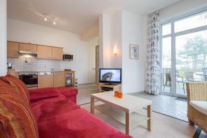 a living room with a red couch and a table at Villa Triton Wohnung 02 in Boltenhagen