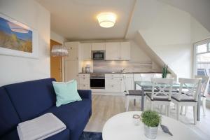 a living room with a blue couch and a table at Villa Triton Wohnung 06 in Boltenhagen