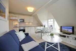 ein Wohnzimmer mit einem blauen Sofa und einem Tisch in der Unterkunft Villa Triton Wohnung 06 in Boltenhagen
