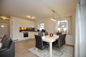 a kitchen and dining room with a table and chairs at Reethaus Am Mariannenweg 20a in Boltenhagen