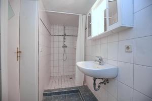 a white bathroom with a sink and a shower at Villa Triton Souterrain Wohnung 07 in Boltenhagen
