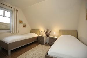 a bedroom with two beds and a window at Reethaus Am Mariannenweg 20a in Boltenhagen