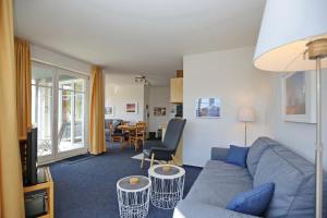 a living room with a blue couch and a table at Dünenblick Wohnung 24 in Boltenhagen