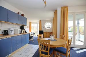 una cucina e una sala da pranzo con tavolo e sedie di Dünenblick Wohnung 24 a Boltenhagen