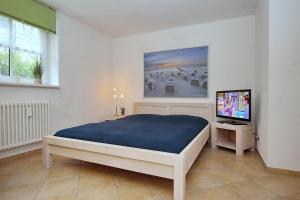 a bedroom with a bed and a television in it at Villa Triton Souterrain Wohnung 09 in Boltenhagen