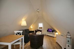 a living room with a couch and a table in a attic at Strandvilla Krabbe Wohnung 07 in Boltenhagen