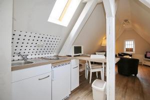 a kitchen with white cabinets and a desk in a attic at Strandvilla Krabbe Wohnung 07 in Boltenhagen