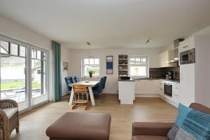 a kitchen and living room with a table and chairs at Reethaus Am Mariannenweg 12a in Boltenhagen