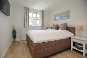 a bedroom with a large bed and a window at Reethaus Am Mariannenweg 09b in Boltenhagen