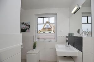 a white bathroom with a sink and a window at Reethaus Am Mariannenweg 18a in Boltenhagen +48 photos