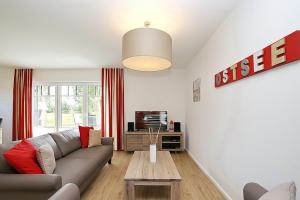 ein Wohnzimmer mit einem Sofa und einem Tisch in der Unterkunft Reethaus Am Mariannenweg 12b in Boltenhagen