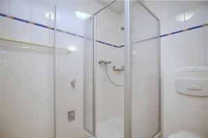 a white bathroom with a shower and a toilet at Likedeeler Wohnung 15 in Boltenhagen