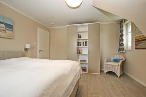 a bedroom with a bed and a book shelf at Reethaus Am Mariannenweg 10a in Boltenhagen