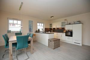 a kitchen with a table and chairs in a room at Reethaus Am Mariannenweg 10a in Boltenhagen