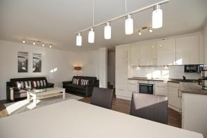 a kitchen and living room with a table and chairs at Reethaus Am Mariannenweg 06b in Boltenhagen