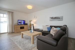 ein Wohnzimmer mit einem Sofa und einem Tisch in der Unterkunft Reethaus Am Mariannenweg 19a in Boltenhagen