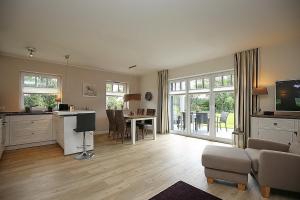a living room with a kitchen and a living room with a table at Reethaus Am Mariannenweg 09b in Boltenhagen