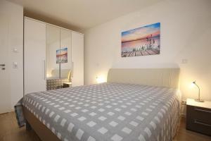 a bedroom with a bed and a painting on the wall at Reethaus Am Mariannenweg 04b in Boltenhagen