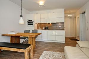 eine Küche mit weißen Schränken und einem Holztisch in der Unterkunft Linden-Palais Wohnung 25 in Heiligendamm