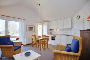 eine Küche und ein Wohnzimmer mit einem Tisch und Stühlen in der Unterkunft Godewind Wohnung 21 in Boltenhagen