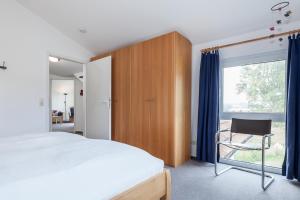 ein Schlafzimmer mit einem Bett, einem Stuhl und einem Fenster in der Unterkunft Godewind Wohnung 21 in Boltenhagen