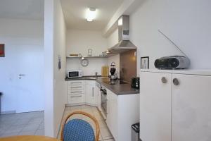 a small kitchen with white cabinets and a sink at Strandvilla Niklot Wohnung 04 in Boltenhagen