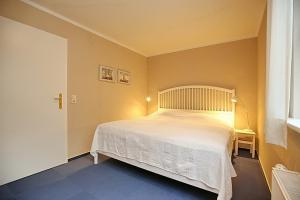a bedroom with a large white bed in a room at Papillon Wohnung 08-1 in Boltenhagen