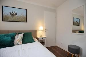 a bedroom with a bed and a table and a mirror at Residenz von Flotow Wohnung 04 in Heiligendamm