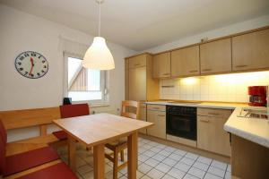 a kitchen with a table and a clock on the wall at Urlauberdorf Haus 21b in Boltenhagen