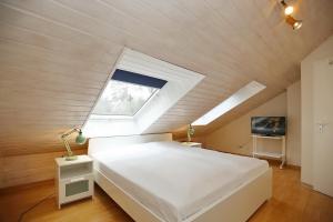 a bedroom with a white bed and a window at Urlauberdorf Haus 21b in Boltenhagen