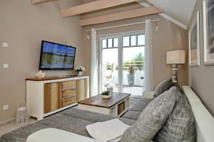 uma sala de estar com um sofá e uma televisão em Haus am Wald Wohnung Sonne em Wittenbeck