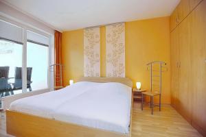 a bedroom with a white bed and a yellow wall at Likedeeler Wohnung 12 in Boltenhagen