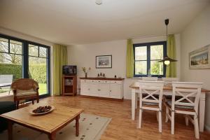 a living room with a table and a dining room at Papillon Wohnung 04-4 in Boltenhagen