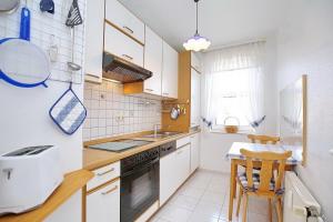 a kitchen with white cabinets and a sink and a table at Sünnslag Wohnung 058 in Boltenhagen
