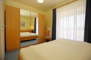 a hotel room with a bed and a mirror at Haffblick Wohnung 20 in Boltenhagen