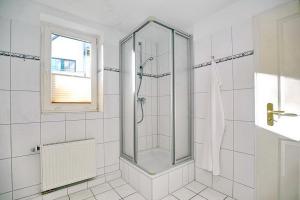 a white bathroom with a shower and a window at Strandvilla Krabbe Wohnung 01 in Boltenhagen