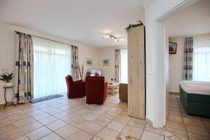 a living room with a bed and a room with a couch at Haus am Teich Wohnung 13 in Boltenhagen