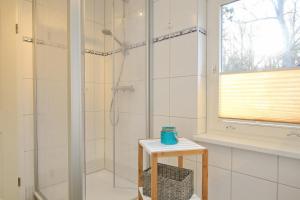 a bathroom with a shower and a table with a stool at Strandvilla Krabbe Wohnung 02 in Boltenhagen
