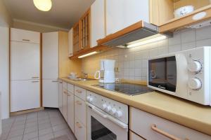 eine Küche mit einer Mikrowelle und einem Herd Top-Backofen in der Unterkunft Goosbrink Wohnung 27 in Boltenhagen
