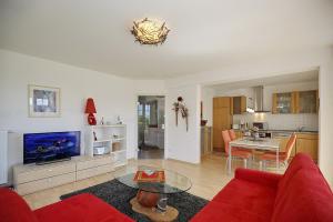 a living room with a red couch and a table at Achtern Diek Wohnung 13 in Boltenhagen