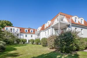 an apartment building with a lawn in front of it at Seebach Wohnung 18 in Boltenhagen